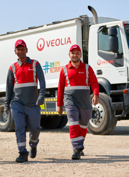 hommes marchent devant camion Veolia