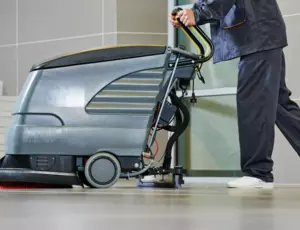 Homme nettoyant le sol avec une machine