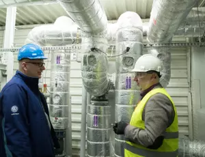 2 hommes discutant devant une installation de récupération de la chaleur fatale