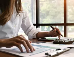 personne qui calcule sur son bureau des CEE pour des financements énergétiques