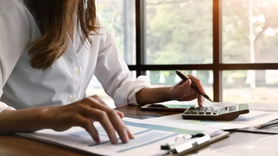 personne qui calcule sur son bureau des CEE pour des financements énergétiques