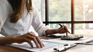personne qui calcule sur son bureau des CEE pour des financements énergétiques